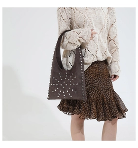 Detail of dark brown retro tote bag with silver studs and matte suede texture