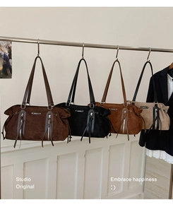 Detailed row of four suede tote bags in coffee, black, brown and beige colors