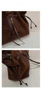 Detail of brown suede tote bag featuring leather straps and premium metal hardware