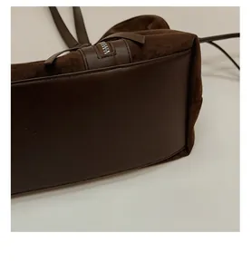 Detailed macro view of the sturdy structured bottom and smooth zipper of brown suede tote