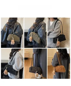 Detail of four matte suede Boston shoulder bags with plush bear charms in various colors