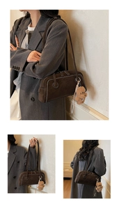 Detail of brown suede shoulder bag featuring white contrast stitching and a plush bear charm