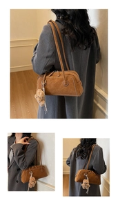 Detail of brown suede shoulder bag with contrast stitching and plush bear charm accessory