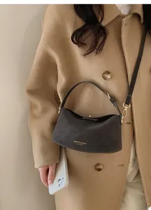 Detail of minimalist dark grey textured leather underarm bag with gold logo text