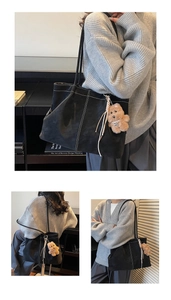 Close-up of black suede tote bag with contrast white stitching and cute bear charm