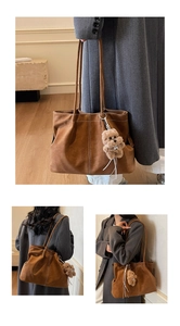Detail of a brown suede tote bag with a plush bear charm and thin shoulder strap