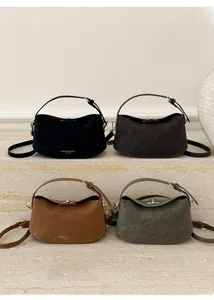 Selection of crescent leather handbags in black, brown, and green with gold buckles