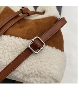 Close-up of brown suede and white faux fur bucket bag with adjustable leather strap