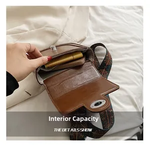 Brown retro saddle bag with ethnic woven strap showing internal capacity for phone and lipstick