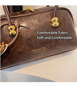 Detalle de la textura de cuero marrón vintage y los herrajes metálicos dorados del bolso tote