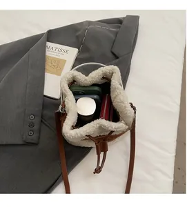 Spacious interior of fluffy bucket bag showing phone, wallet and bottle storage
