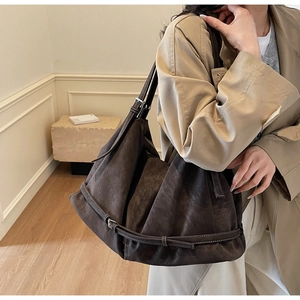 Detail einer dunkelbraunen Leder-Tote-Bag mit verstellbaren Trägern und Metallschnallen an Schulter
