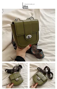Detail of olive green vintage saddle bag with ethnic printed wide strap and metal lock