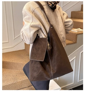 Détail du grand sac cabas en daim marron avec surpiqûres blanches et petite pochette