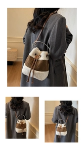 Detail of suede bucket bag with faux fur trim, silver metal ring handle and drawstrings