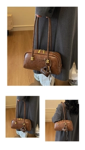 Detalle del bolso Boston marrón vintage con herrajes dorados y logotipo grabado