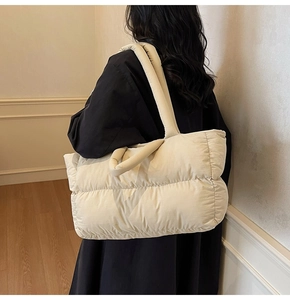 Detailed side view of off-white padded tote bag showing soft quilted puffy texture