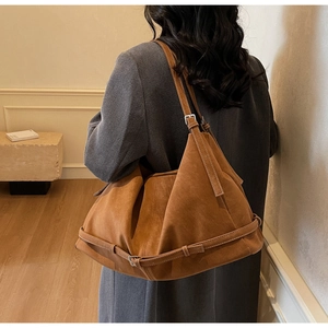 Close-up of large brown tote bag showing contrast stitching and retro buckle detail