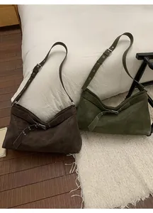 Detail of matte leather tote bags with adjustable wide straps and metallic buckle decor