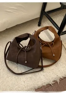 Detail view of bow-knot suede tote bags in dark coffee and caramel brown finishes