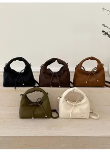 Detailed close-up of crescent handbags featuring knotted handles and silver metallic drawstring
