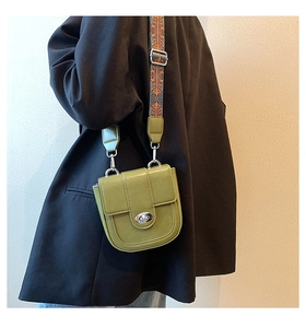 Olive green saddle bag with ethnic pattern strap shown on model in black blazer