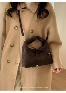 Detail of dark brown retro crossbody bag featuring a delicate front ribbon bow decoration