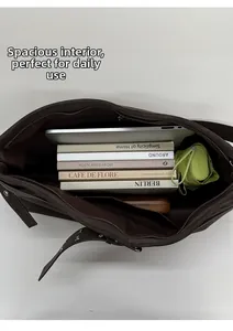 Detailed interior of a large brown shoulder bag showing laptop and daily items storage