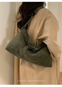 Deep green suede tote bag detail with adjustable strap and metallic eyelet hardware