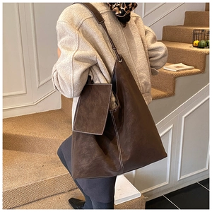 Détail d'un sac hobo en daim vintage avec surpiqûres et porte-cartes attaché
