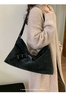 French retro black shoulder bag with silver eyelet belt detail on beige knitwear