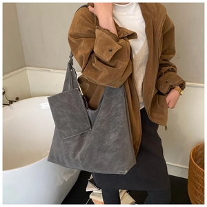 Detail of dark grey suede tote bag set with contrast stitching and inner pouch
