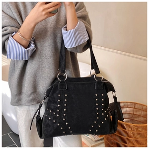 Gros plan du sac cabas en daim noir avec rivets argentés vintage et anneaux métalliques
