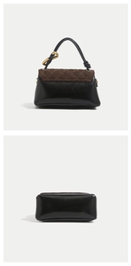 Detail of glossy black leather handbag with brown quilted suede flap and gold ring hardware