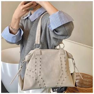 Gros plan des rivets argentés et du cuir texturé sur ce grand sac cabas pour femme