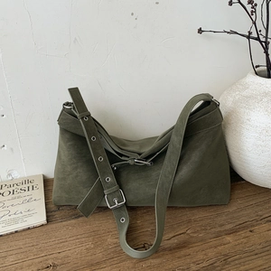 Macro view of olive green suede tote bag with adjustable metal buckle strap detail