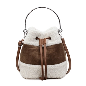 Détail du sac seau en peluche avec poignée en métal, peau de mouton et daim contrasté