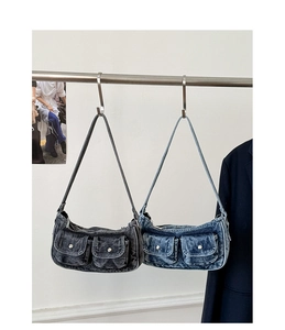 Close-up of denim shoulder bags with vintage silver rivets and utility pockets