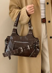 Close-up of vintage brown leather tote bag with silver hardware and buckles