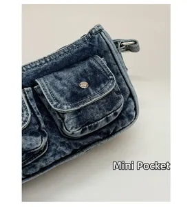 Detailed close-up of a dark blue washed denim bag featuring a mini pocket and silver button