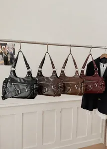 Four punk style shoulder bags in black, brown, caramel, and burgundy with rivet details