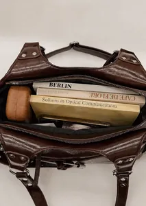 Interior view of large brown vintage tote bag filled with books and personal items