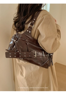 Detail of dark brown faux leather tote with silver zippers and belt-style shoulder strap