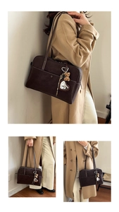 Detail of deep brown Boston shoulder bag with contrast stitching and leopard bear charm