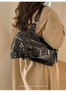 Detail of black motorcycle tote bag with metallic buckles and zipper pockets for Y2K style