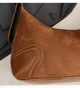 Dettaglio delle cuciture in camoscio e pelle marrone caramello di questa borsa a tracolla retrò