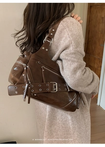 Detailed view of brown retro tote bag with silver hardware and belt buckle strap