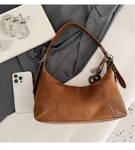 Dettaglio borsa hobo in camoscio marrone con ciondolo abaco e tracolla per riferimento taglia