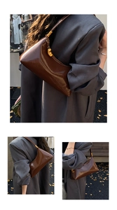 Détail d'un sac à bandoulière en cuir brillant marron avec finitions dorées chic
