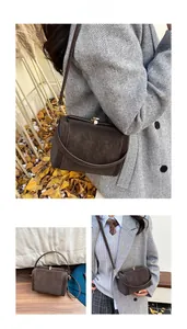 Détails de la bandoulière en daim marron foncé avec un fermoir en métal doré vintage